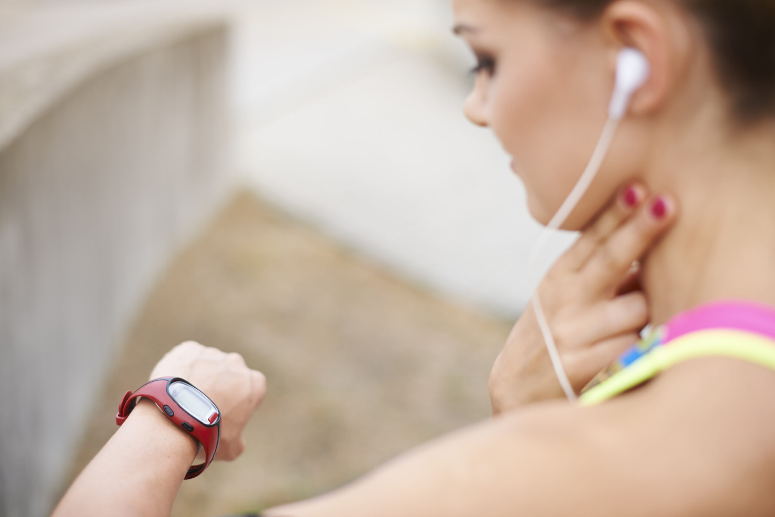 a young woman wears an ecg smartwatch and checks her pulse manually